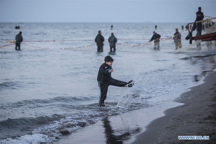 A boy plays with water as Iranian fishermen work at the Caspian sea beach near Anzali Port, northern Iran, on March 27, 2017. (Xinhua/Ahmad Halabisaz)  A boy plays with water as Iranian fishermen work at the Caspian sea beach near Anzali Port, northern Iran, on March 27, 2017. (Xinhua/Ahmad Halabisaz)