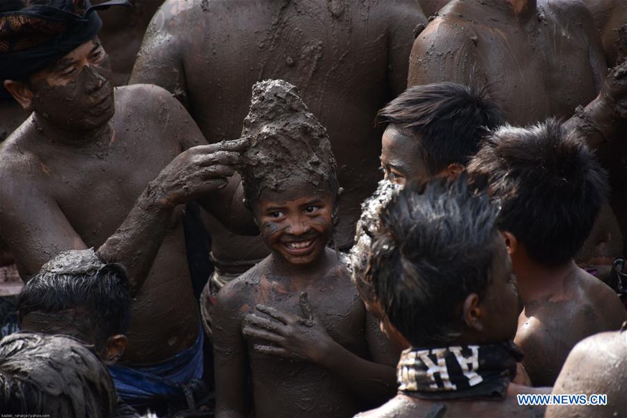 Balinese men put mud on a boy's body during mud baths tradition known as Mebuug-buugan, in Bali, Indonesia, March 29, 2017. The Mebuug-buugan is held a day after Nyepi aimed at neutralizing bad traits. (Xinhua/Kadek)  Balinese men put mud on a boy's body during mud baths tradition known as Mebuug-buugan, in Bali, Indonesia, March 29, 2017. The Mebuug-buugan is held a day after Nyepi aimed at neutralizing bad traits. (Xinhua/Kadek)