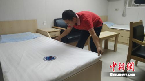 李紅民在遠望7號的住艙中鋪床,如今的床鋪干燥舒適,房間明亮寬敞。 溫孟馨 攝 點擊進入下一頁
